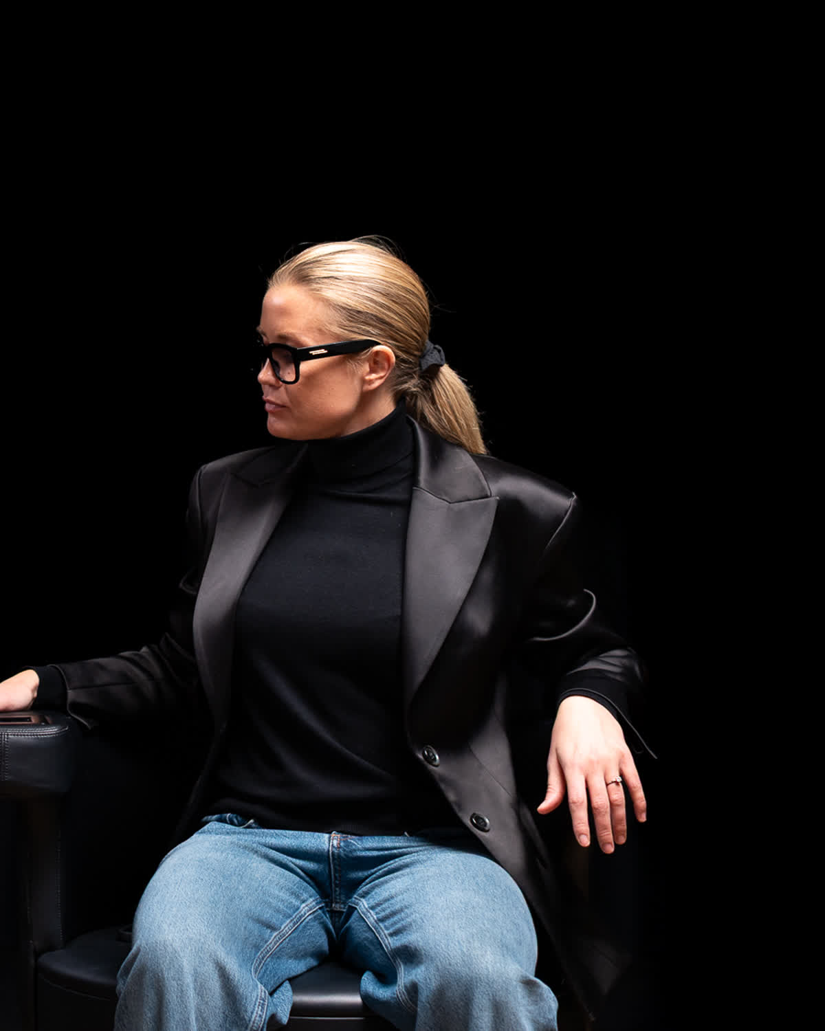 Kvinna som sitter fullt påklädd i Insculpt Chair medan behandlaren ställer in programmet på armstödets pekskärm