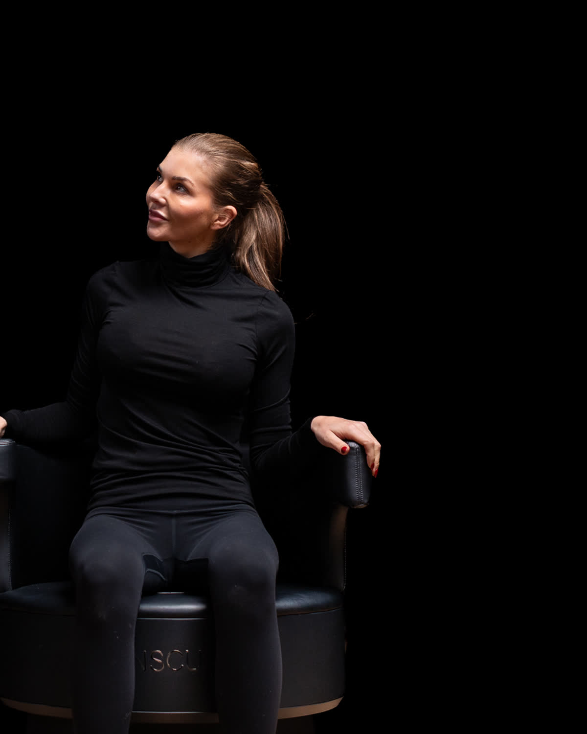 Kvinna fullt påklädd i Insculpt Chair under en bäckenbottenbehandling
